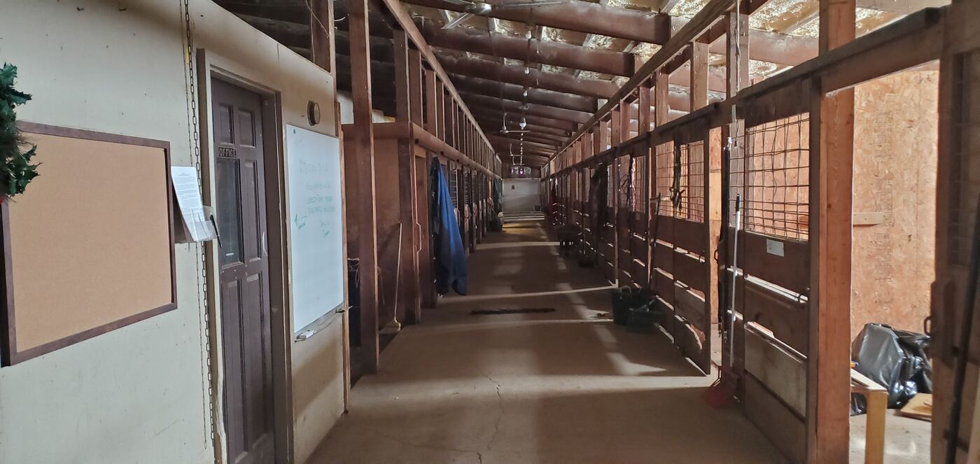 The barn aisle between rows of stalls